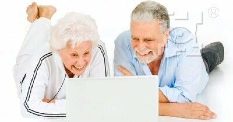 zdjęcie: Webinarium z zakresu cyberbezpieczeństwa / fot. UM Lublin / Seniorzy przy laptopie. Seniorka w białym dresie oraz senior w błękitnej koszuli i ciemnych spodniach leżą na podłodze i wpatrują się w biały laptop.